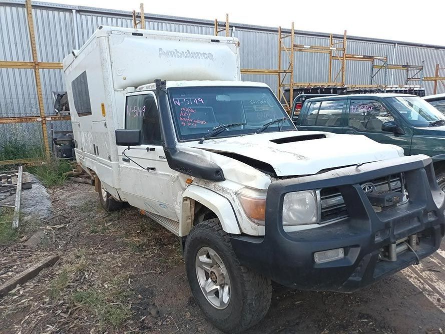 A White Truck with a Camper on Top of It is Parked in a Lot — South West 4WD Wreckers In Brisbane, QLD