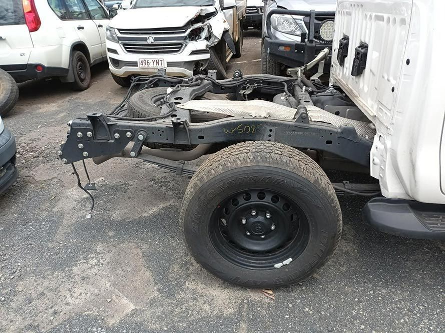 A White Truck is Being Dismantled in a Parking Lot — South West 4WD Wreckers in Harristown, QLD 