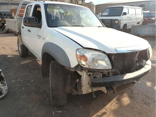 A White Truck With a Broken Bumper is Parked in a Lot — South West 4WD Wreckers In Harristown, QLD