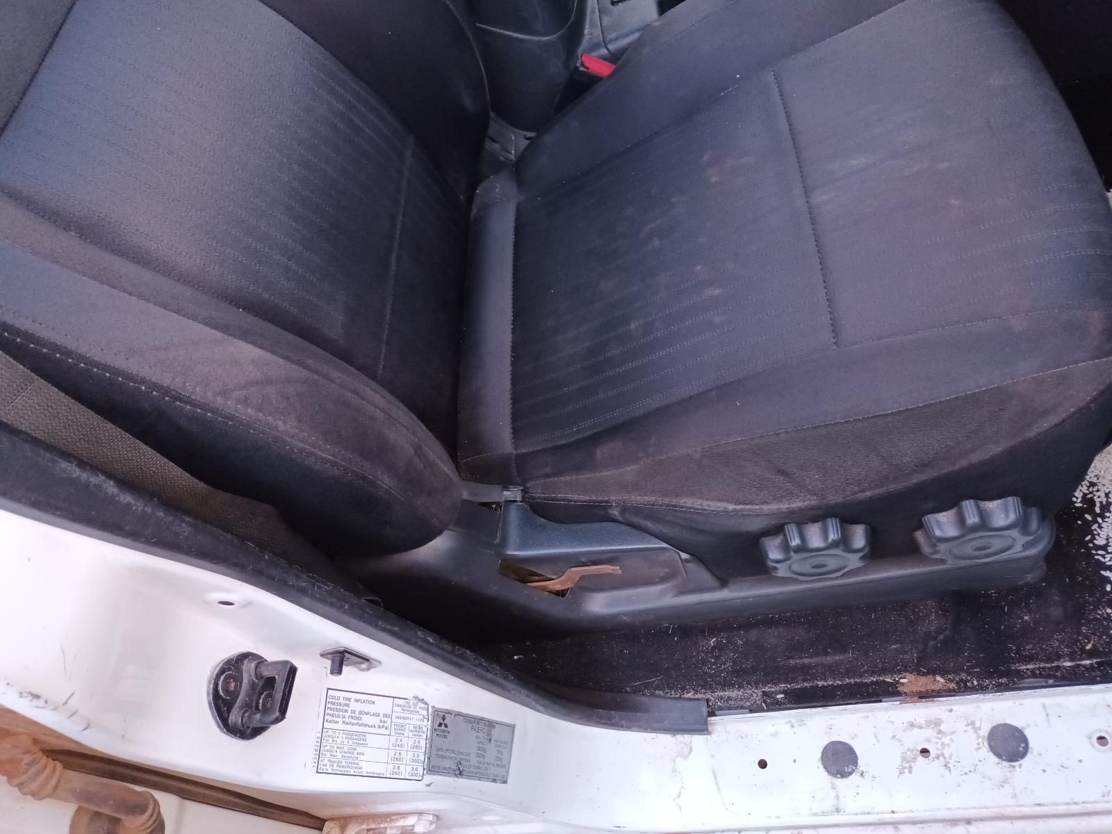 A Dirty Car Seat is Sitting in the Doorway of a White Car — South West 4WD Wreckers In Brisbane, QLD