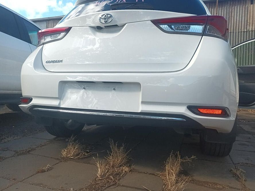 The Rear End of a White Toyota Corolla is Parked in a Parking Lot — South West 4WD Wreckers in Harristown, QLD