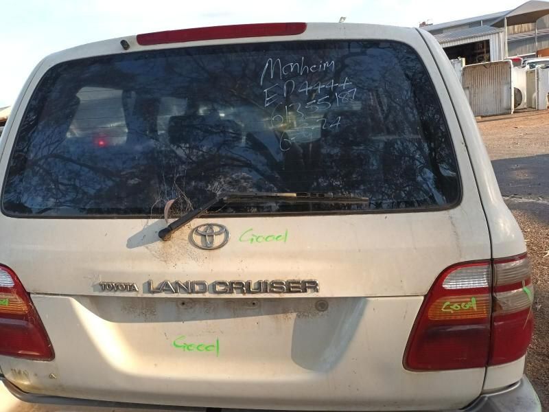 A White Toyota Land Cruiser is Sitting in a Parking Lot — South West 4WD Wreckers In Harristown, QLD