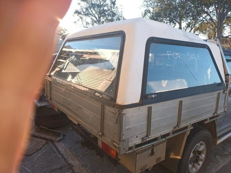 A Truck With a Canopy on Top of It is Parked on the Side of the Road — South West 4WD Wreckers In Brisbane, QLD