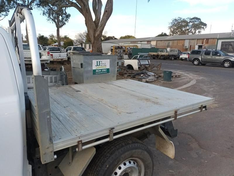 A White Truck With a Flat Bed is Parked in a Parking Lot — South West 4WD Wreckers In Brisbane, QLD