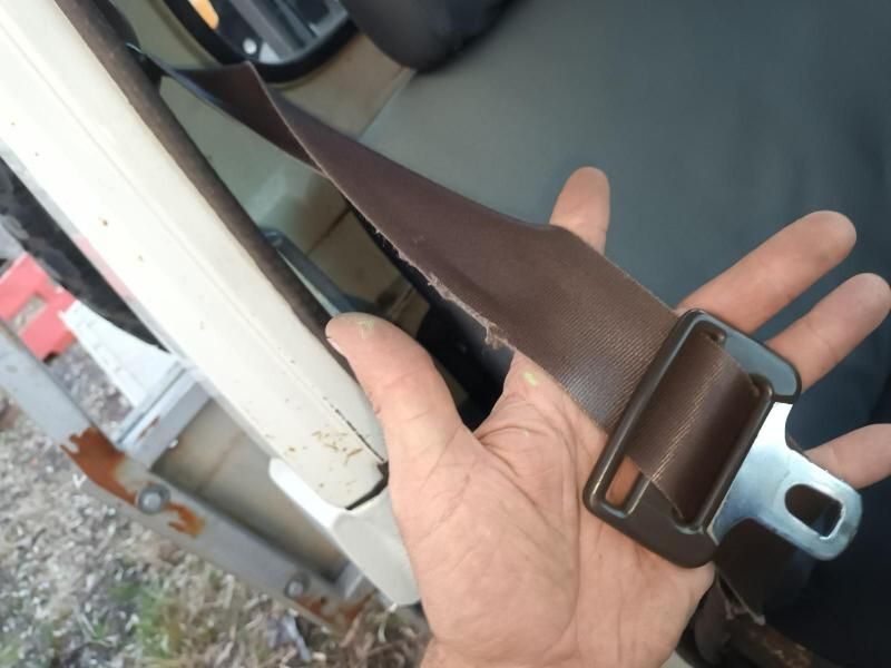 A Person is Holding a Brown Seat Belt in Their Hand — South West 4WD Wreckers In Brisbane, QLD