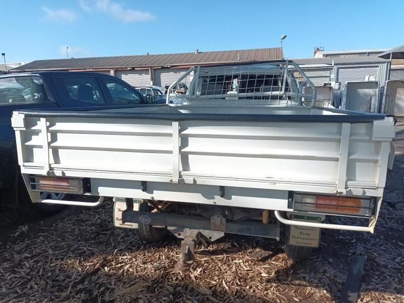 A White Truck is Parked in the Dirt in Front of a Building — South West 4WD Wreckers In Brisbane, QLD