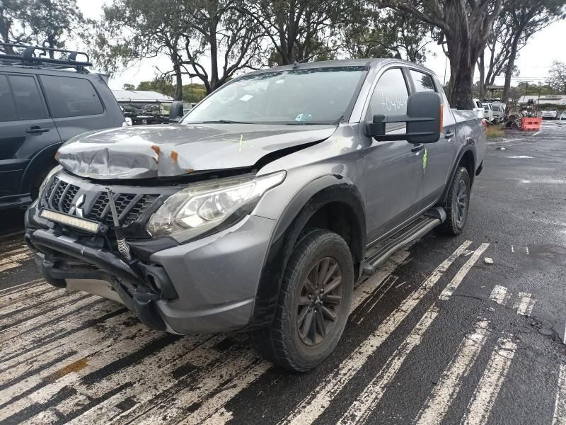 A Damaged Mitsubishi Triton Pickup Truck is Parked in a Parking Lot — South West 4WD Wreckers In Brisbane, QLD
