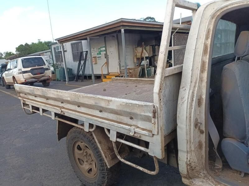 A White Truck With a Ladder on the Back is Parked on the Side of the Road — South West 4WD Wreckers In Brisbane, QLD