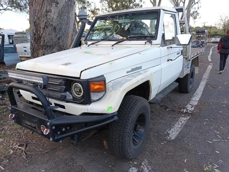 A White Truck is Parked on the Side of the Road Next to a Tree — South West 4WD Wreckers In Brisbane, QLD