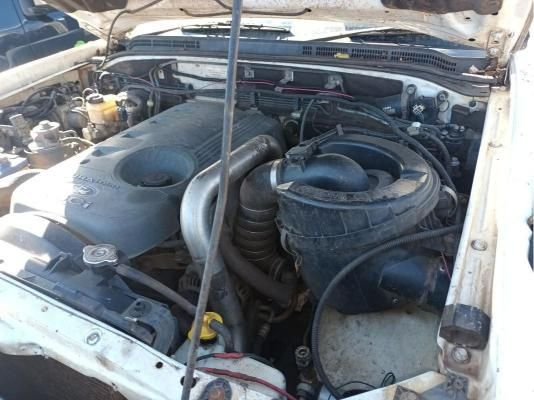 The Engine of a White Car With the Hood Open — South West 4WD Wreckers In Harristown, QLD