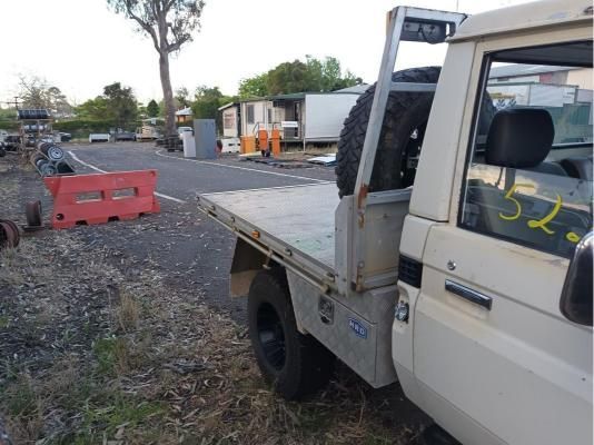 A White Truck With a Flat Bed is Parked on the Side of the Road — South West 4WD Wreckers In Brisbane, QLD