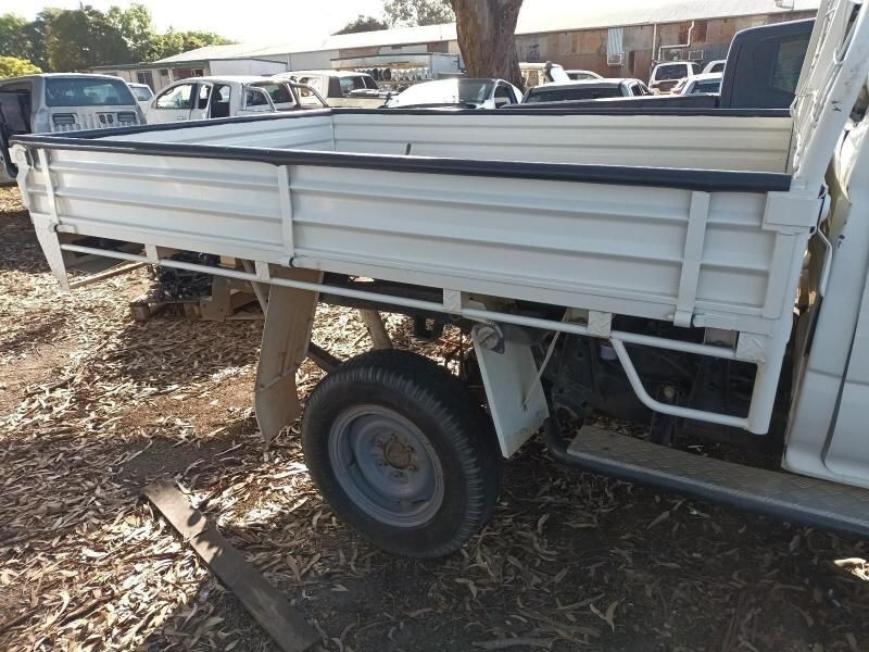 A White Truck With a Flat Bed is Parked in the Dirt — South West 4WD Wreckers In Brisbane, QLD