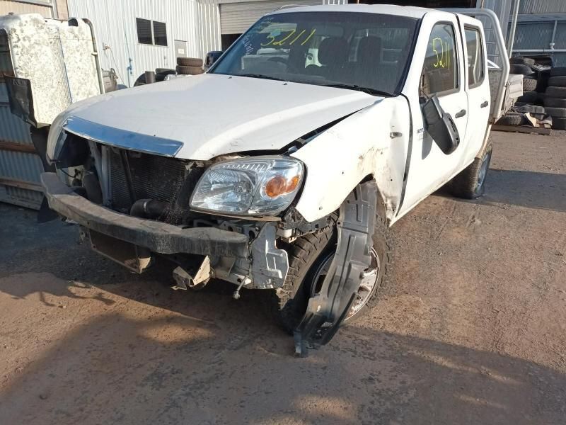 A White Truck With a Broken Bumper is Parked in a Lot — South West 4WD Wreckers In Harristown, QLD