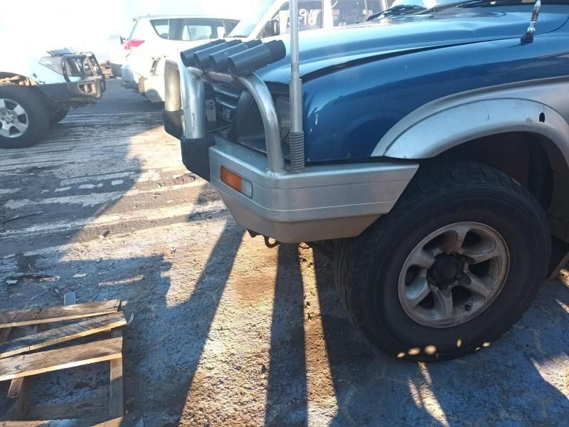 A Blue Truck is Parked in a Parking Lot Next to a Wooden Pallet — South West 4WD Wreckers In Brisbane, QLD