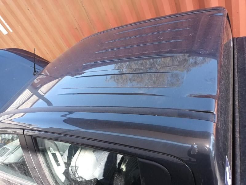 The Roof of a Black Car is Sitting in Front of a Red Wall — South West 4WD Wreckers In Harristown, QLD