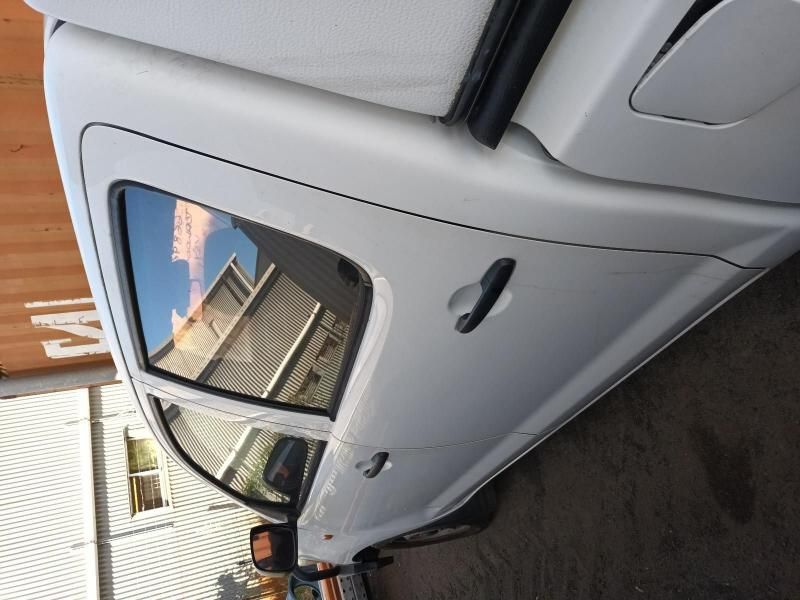 A White Car is Parked in Front of a Building With the Letter M on It — South West 4WD Wreckers In Harristown, QLD
