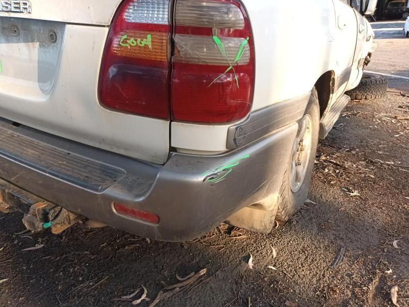 A White Car With a Damaged Bumper is Parked on the Side of the Road — South West 4WD Wreckers In Harristown, QLD