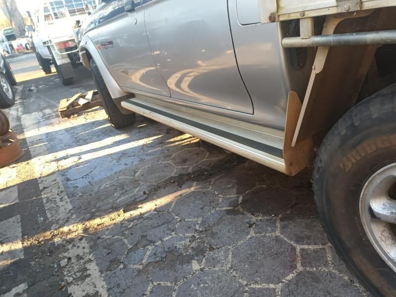A Silver Car With a Tire That Says Bridgestone on It— South West 4WD Wreckers In Brisbane, QLD