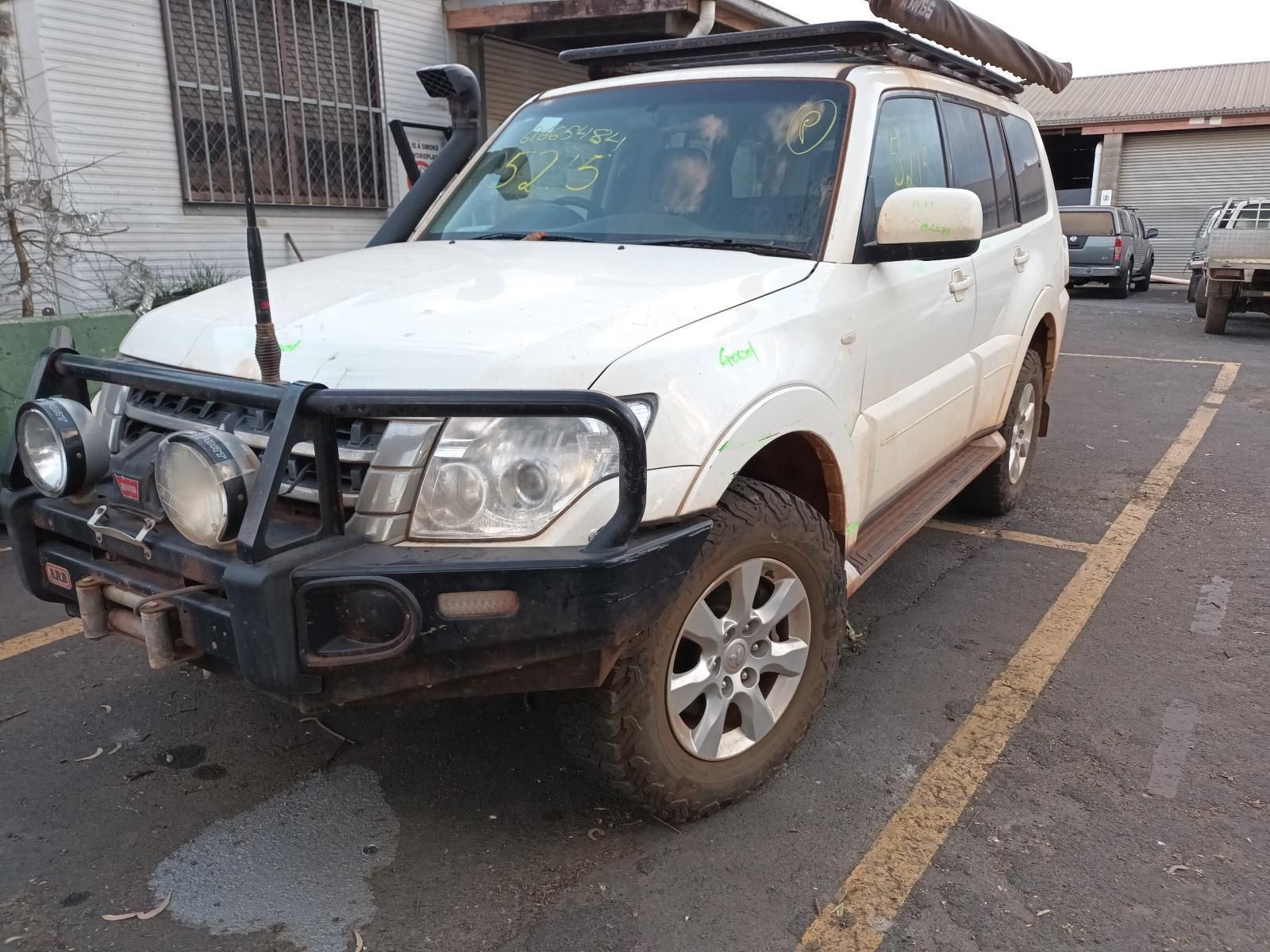 A White Suv is Parked in a Parking Lot in Front of a Building — South West 4WD Wreckers In Brisbane, QLD