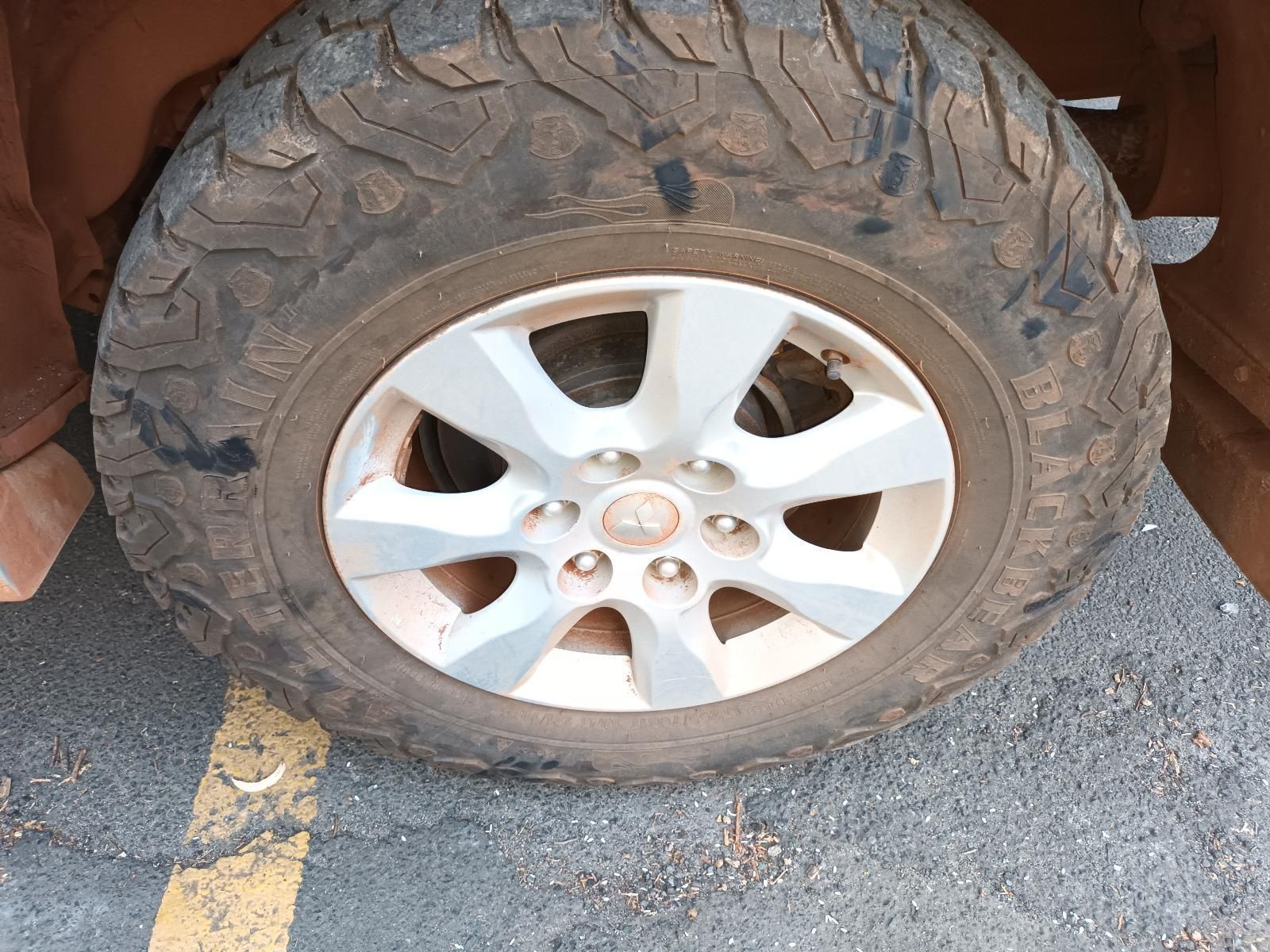 A Close Up of a Tire on a Car in a Parking Lot — South West 4WD Wreckers In Brisbane, QLD
