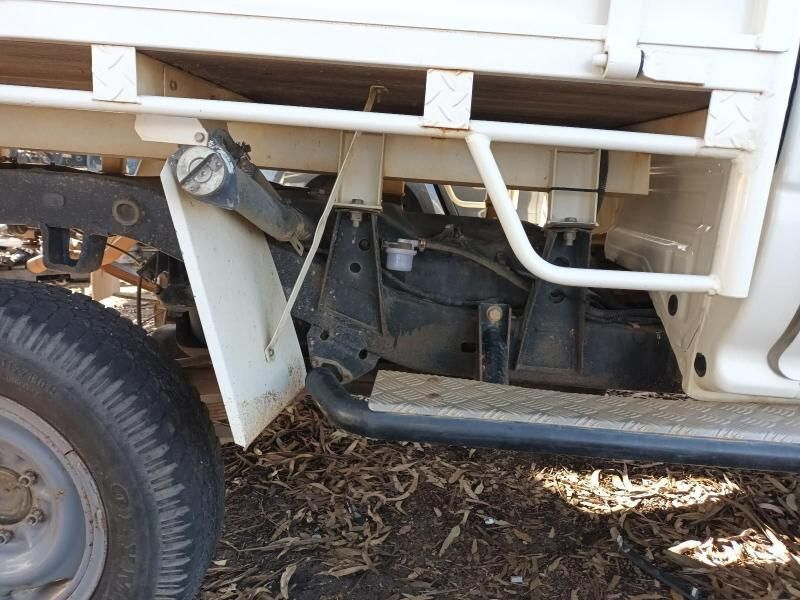 A White Truck With a Black Tire is Parked in the Dirt — South West 4WD Wreckers In Brisbane, QLD