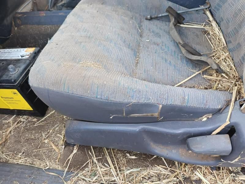 A Car Seat is Sitting in the Grass Next to a Battery — South West 4WD Wreckers In Brisbane, QLD