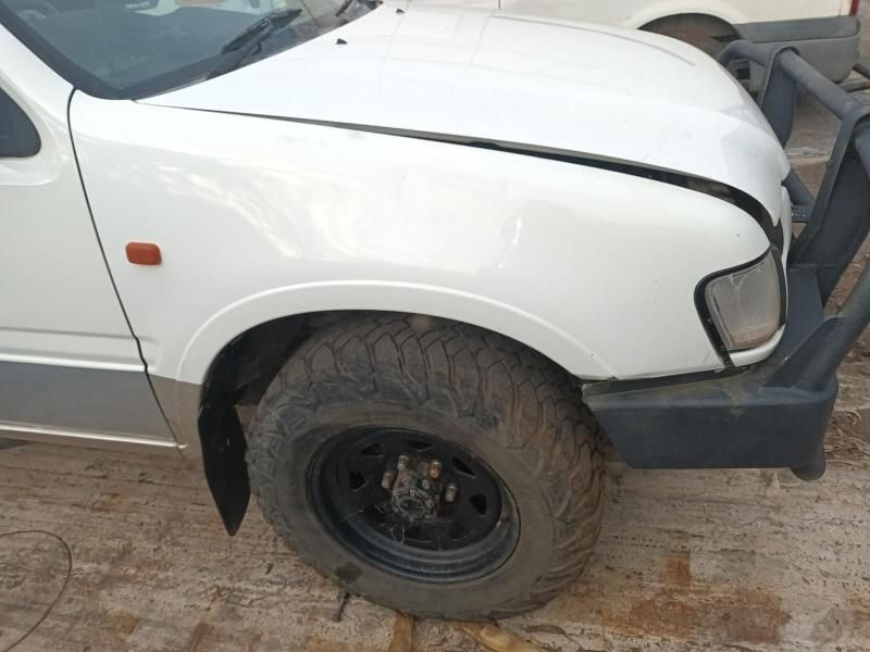 A White Truck With a Broken Fender is Parked on the Side of the Road — South West 4WD Wreckers In Harristown, QLD