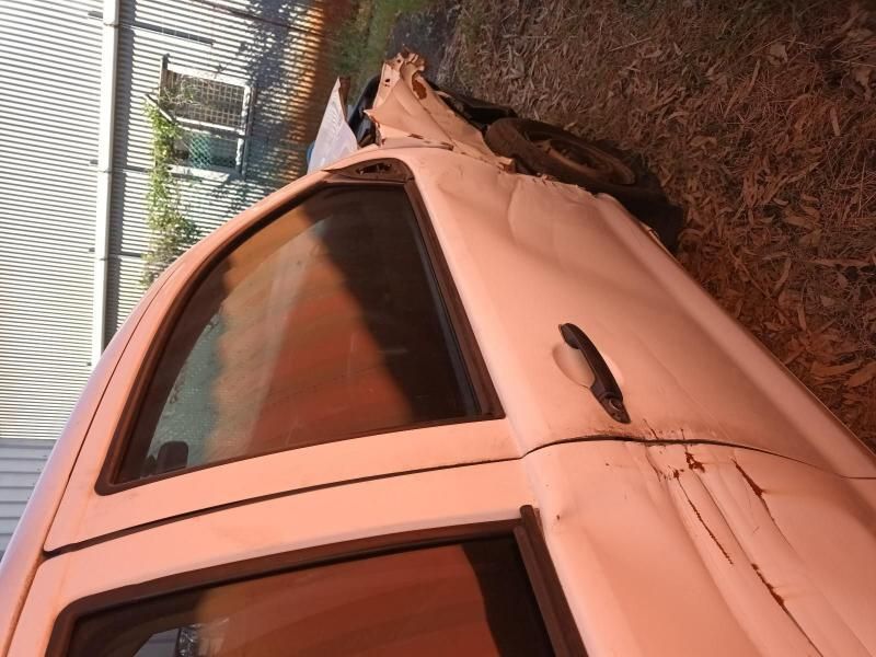 A White Car With a Broken Door is Sitting on the Ground — South West 4WD Wreckers In Harristown, QLD