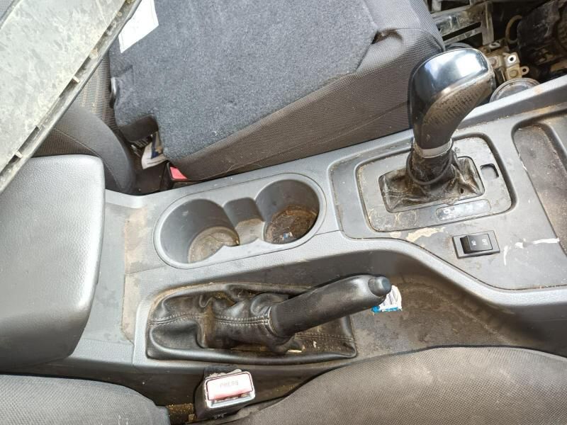 A Dirty Car Console With Cup Holders and a Shifter — South West 4WD Wreckers In Brisbane, QLD