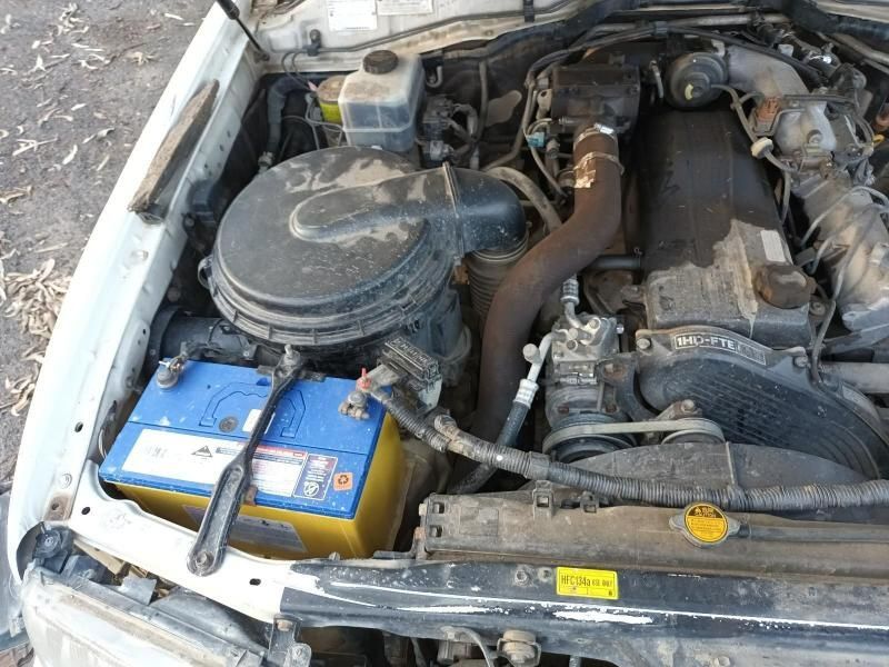 A Close Up of a Car Engine With a Blue Battery — South West 4WD Wreckers In Harristown, QLD