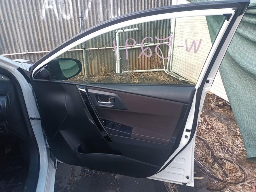 A White Car with the Door Open is Parked in Front of a Building — South West 4WD Wreckers in Harristown, QLD