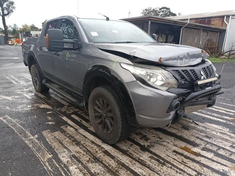 A Damaged Mitsubishi Triton Pickup Truck is Parked in a Parking Lot — South West 4WD Wreckers In Brisbane, QLD