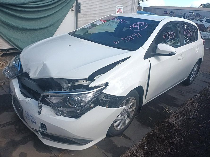 A White Car with a Damaged Front End is Parked on a Sidewalk — South West 4WD Wreckers in Harristown, QLD