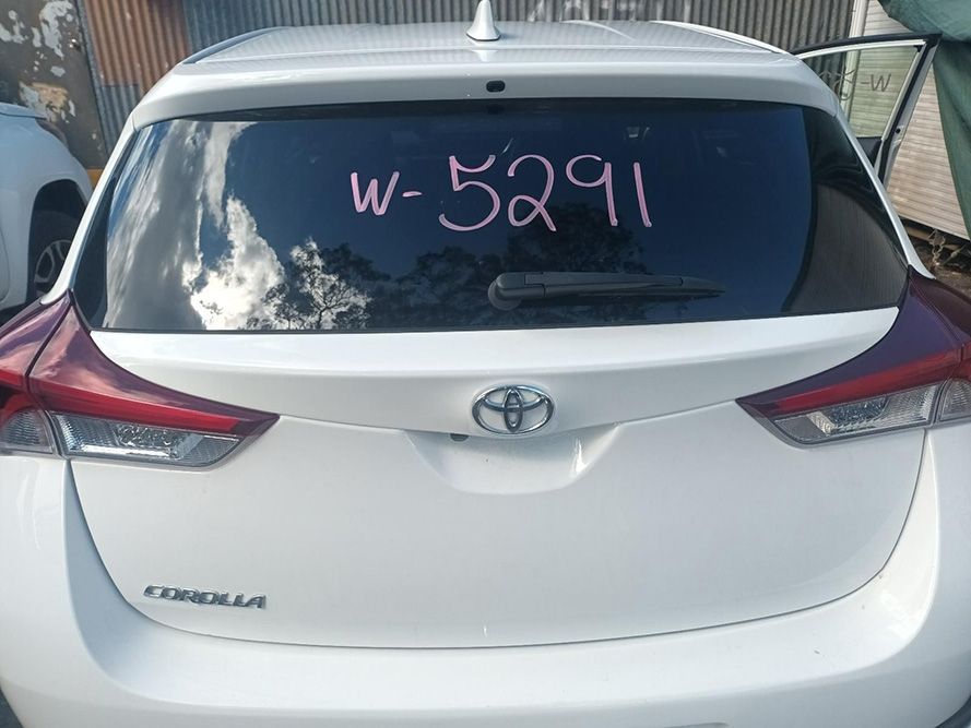 A White Toyota Corolla is Parked in Front of a Building — South West 4WD Wreckers in Harristown, QLD