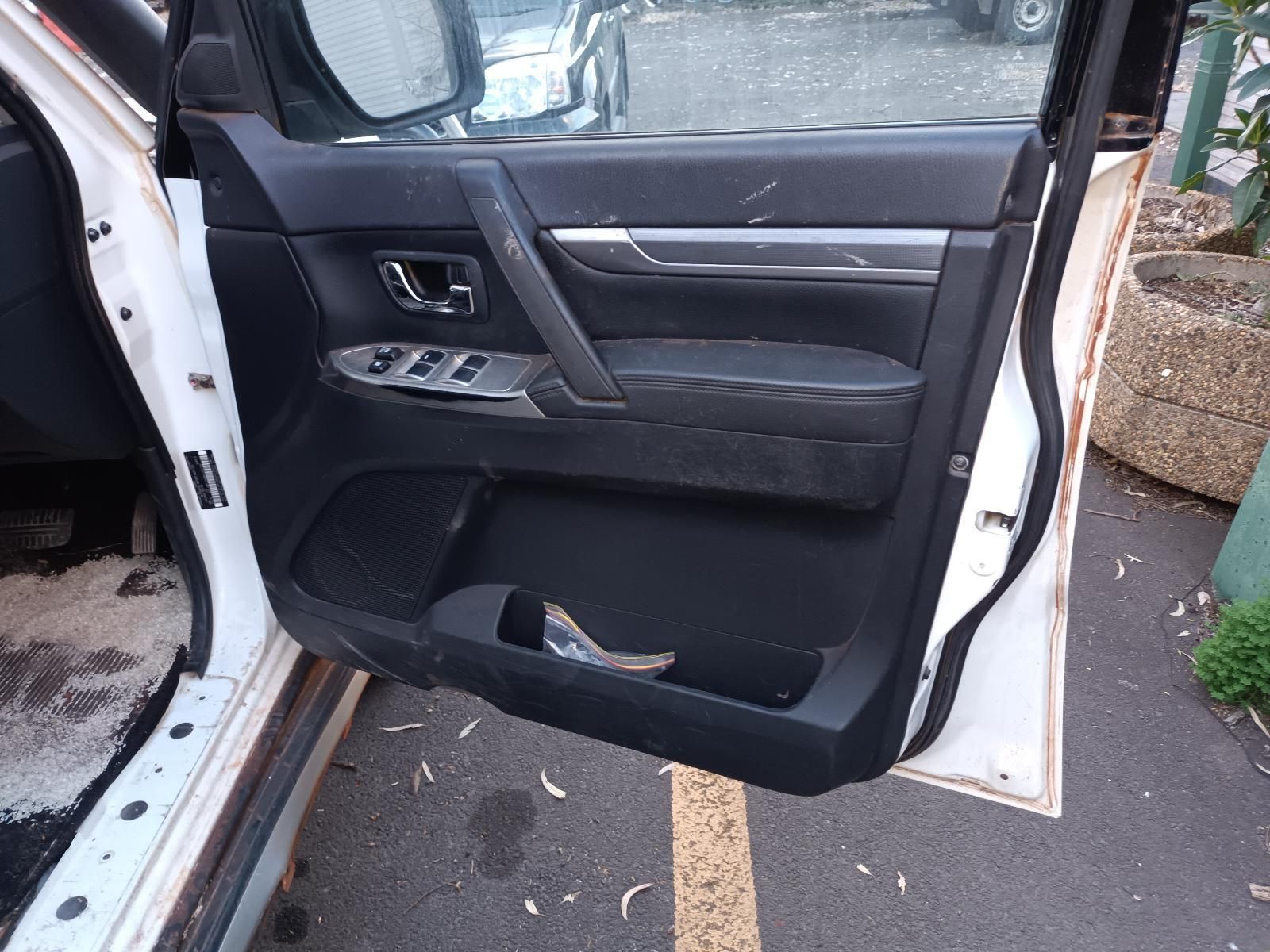 A White Car With the Door Open is Parked on the Side of the Road — South West 4WD Wreckers In Brisbane, QLD