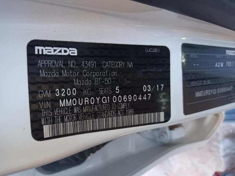 A White Mazda Car Has a Sticker on the Side That Says Approval No 43491 — South West 4WD Wreckers In Harristown, QLD