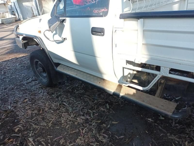 A White Truck is Parked in a Pile of Wood Chips — South West 4WD Wreckers In Brisbane, QLD