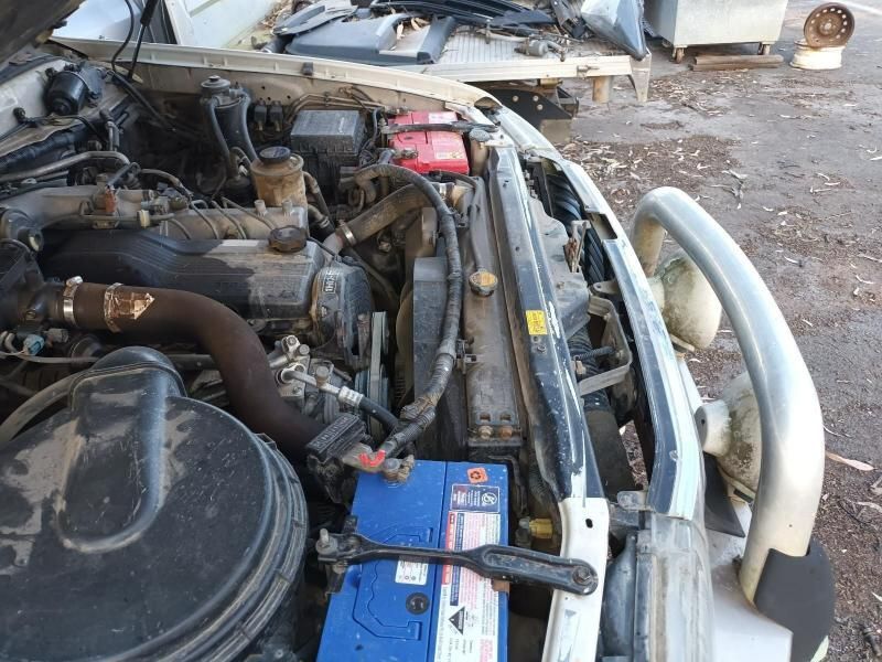 A Blue Battery is Sitting Under the Hood of a Car — South West 4WD Wreckers In Harristown, QLD