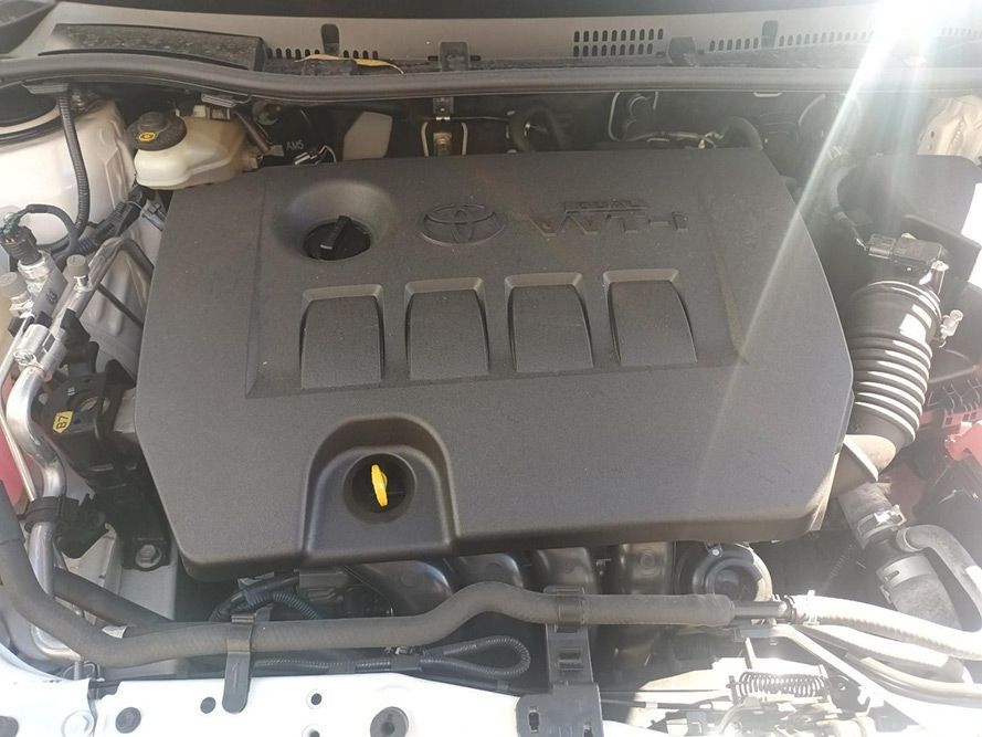 The Engine of a White Toyota Corolla is Visible Under the Hood — South West 4WD Wreckers in Harristown, QLD