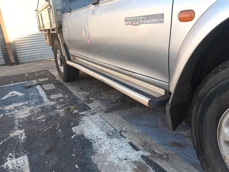 A Silver Triton Truck is Parked on the Side of the Road — South West 4WD Wreckers In Brisbane, QLD