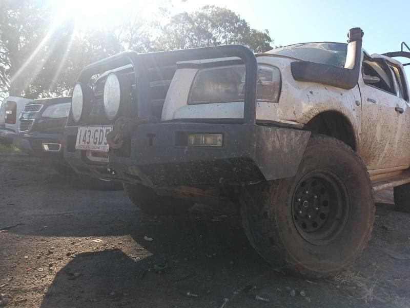 A White Truck With a Black Bumper is Parked in a Dirt Lot — South West 4WD Wreckers In Harristown, QLD