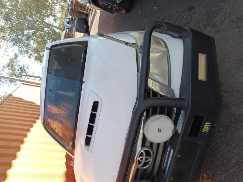 A White Toyota Truck is Parked on the Street — South West 4WD Wreckers In Harristown, QLD