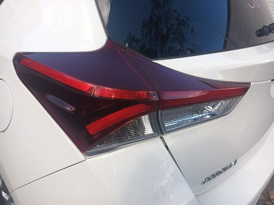A White Car with a Red Tail Light is Parked on the Side of the Road — South West 4WD Wreckers in Harristown, QLD