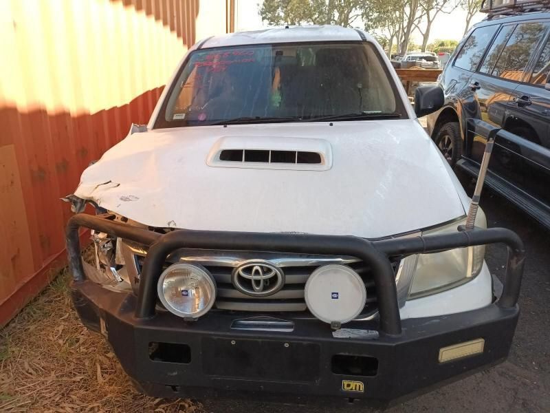 A White Toyota With a Black Bumper is Parked Next to a Red Container — South West 4WD Wreckers In Harristown, QLD