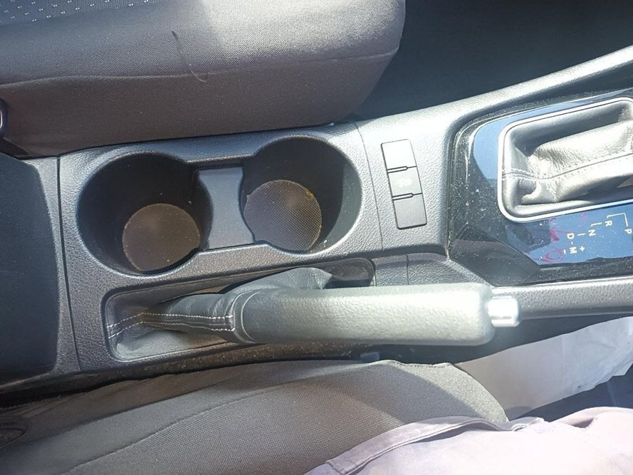 A Person is Sitting in a Car with a Cup Holder and a Handbrake — South West 4WD Wreckers in Harristown, QLD