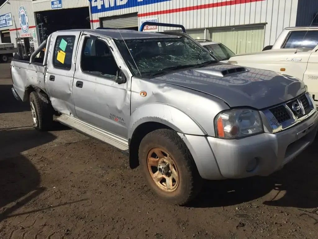 A Silver Nissan Pickup Truck is Parked in Front of a Building — South West 4WD Wreckers In Brisbane, QLD