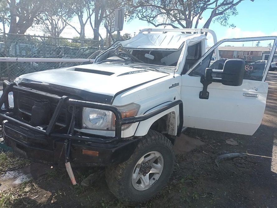 A White Truck with the Doors Open is Parked in the Dirt — South West 4WD Wreckers in Harristown, QLD