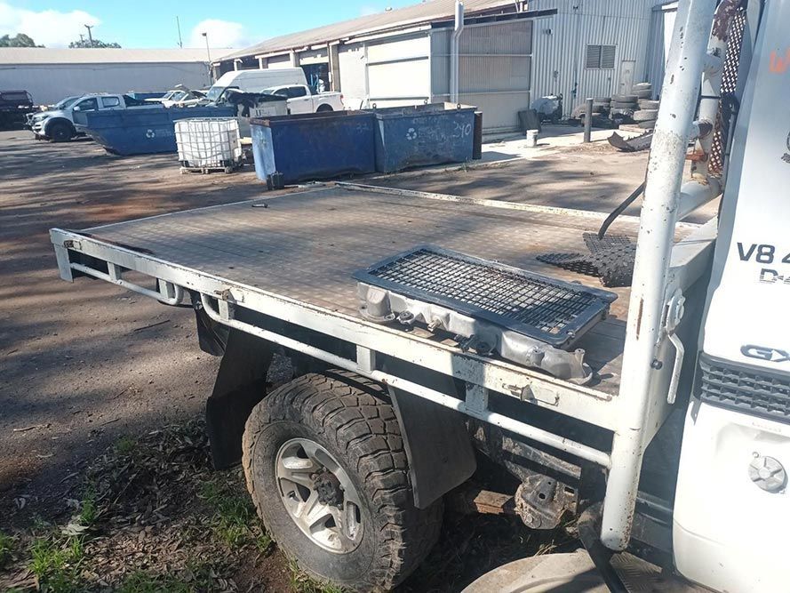 A White Truck with a Flat Bed is Parked in a Parking Lot — South West 4WD Wreckers in Harristown, QLD