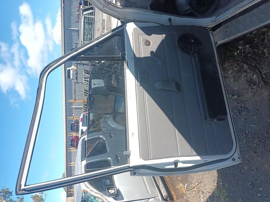 A White Car with the Door Open is Parked on the Side of the Road — South West 4WD Wreckers in Harristown, QLD