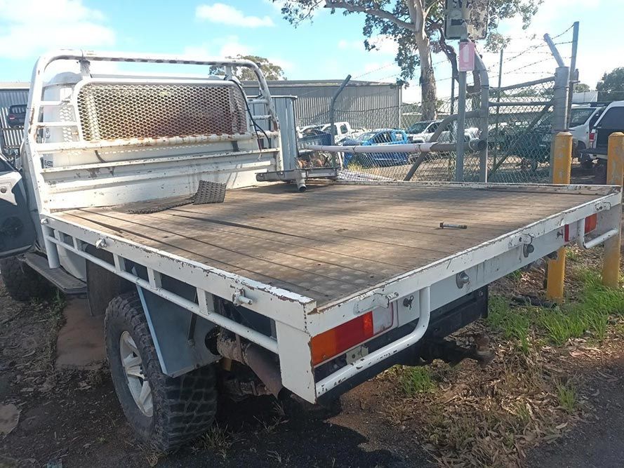 A White Truck with a Flat Bed is Parked in a Parking Lot — South West 4WD Wreckers in Harristown, QLD